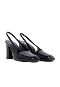 Tacones de charol negro tipo slingback con punta redonda y tacones cuadrados sobre un fondo blanco.