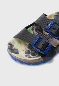 Sandalo scivolo sintetico nero con fibbie blu, cinturini testurizzati e soletta decorata con elementi verdi e grafici.