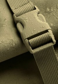 Olive zielony, teksturowany materiał z kroplami wody, z solidną plastikową klamrą i paskiem wykonanym z tkaniny plecionej.