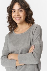 Lys grå strikket sweater med rund halsudskæring, der har ribbede detaljer på ærmerne og en glat kropsstruktur.