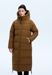Bruine gewatteerde lange jas met een hoge kraag en capuchon. Deze heeft een centrale rits, zijzakken en een rechte snit. Geweven panelen zijn zichtbaar.
