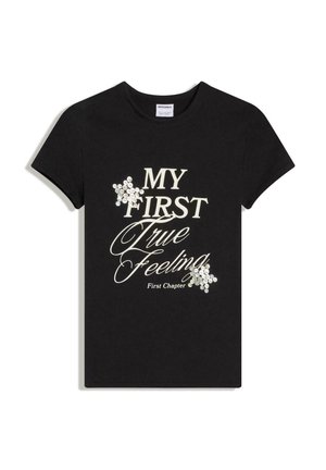 Čierne tričko s krátkym rukávom s bielym textom "MY FIRST True Feeling First Chapter" a dvoma zhlukmi bielych flitrov v tvare hviezd.