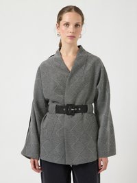Chaqueta envolvente de patrón gris y negro con mangas anchas, que presenta un cinturón ceñido a la cintura y líneas diagonales en un diseño de cuadrícula.