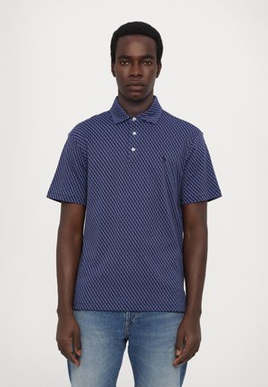 Marineblauwe polo met een geometrisch patroon, korte mouwen, een knoopsluiting met twee knopen en een subtiel logo. Gemaakt van ademend materiaal, ontworpen voor comfort.