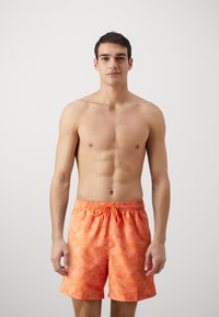 Șorturi de înot portocalii strălucitoare, cu un model de frunze de palmier, talie elastică cu șnur și o croială lejeră, potrivite pentru plajă.