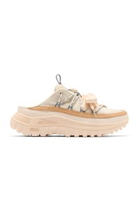 Beige slip-on sneaker with thick rugged sole, mixed materials, two-tone laces, and a large bow detail on top.
