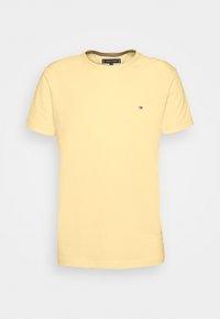 T-shirt di cotone gialla con maniche corte, collerotondo, con un piccolo logo sul lato sinistro del petto. Tessuto morbido, design casual.