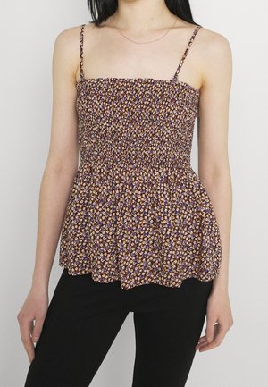 Smocked floral top with thin straps, featuring a pattern of small purple and orange flowers on a dark background. Flared hem design.