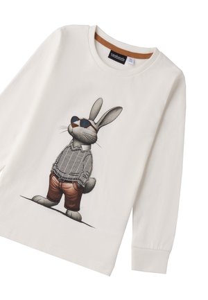 Camicia a maniche lunghe di colore crema con una stampa di un coniglio dei cartoni animati che indossa occhiali da sole, un maglione a righe e pantaloni marroni. Etichetta visibile all'interno del colletto.