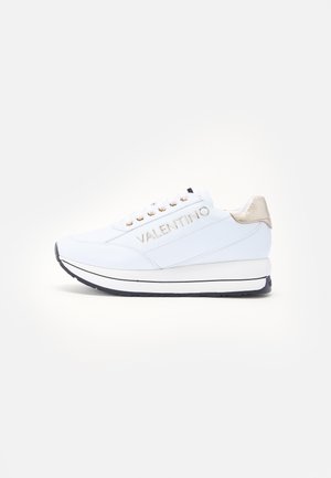 Białe sneakersy ze skóry z złotymi akcentami, z podniesioną podeszwą i logo po boku. Okrągły czubek i system wiązania.
