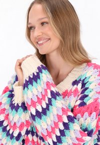 Pulover tricotat multicolor, cu o croială lejér, având decolteu în V, manșete strâmte și un model din fire de culoare teal, roz, mov și crem.