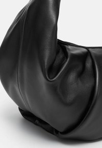 Borsa a tracolla in pelle nera con una superficie morbida e testurizzata, caratterizzata da un design morbido e una forma arrotondata. Nessuna ferramenta o accenti visibili.
