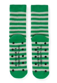 Calzini a righe verdi e grigie con bordo a coste. La suola presenta puntini antiscivolo neri e testo stampato lungo il centro. Tessuto morbido a maglia.