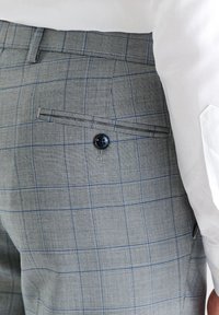 Szare spodnie w kratę z delikatnym wzorem w kratkę, z zapięciem na guzik w tylnej kieszeni oraz gładkim, teksturowanym wykończeniem.