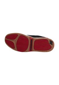 Black sneaker sole with red rubber traction pattern and light brown side edges. Features "DC SHOE CO USA" branding on the lateral side.