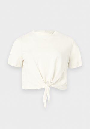 Crop top blanc à manches courtes avec col rond et détail noué à l'avant sur fond clair uni.