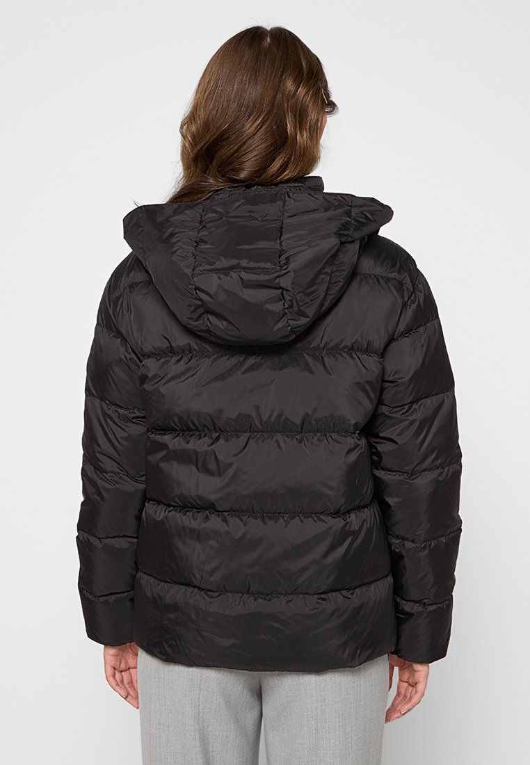 Schwarze Pufferjacke mit Kapuze, mit gesteppten Bereichen, glänzender Textur und elastischen Bündchen. Die Rückansicht zeigt das strukturierte Design.