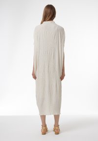 Witte, getextureerde midi-jurk met een gegraveerd patroon van bochten en bladachtige ontwerpen. Relaxte pasvorm, ronde halslijn en korte mouwen.