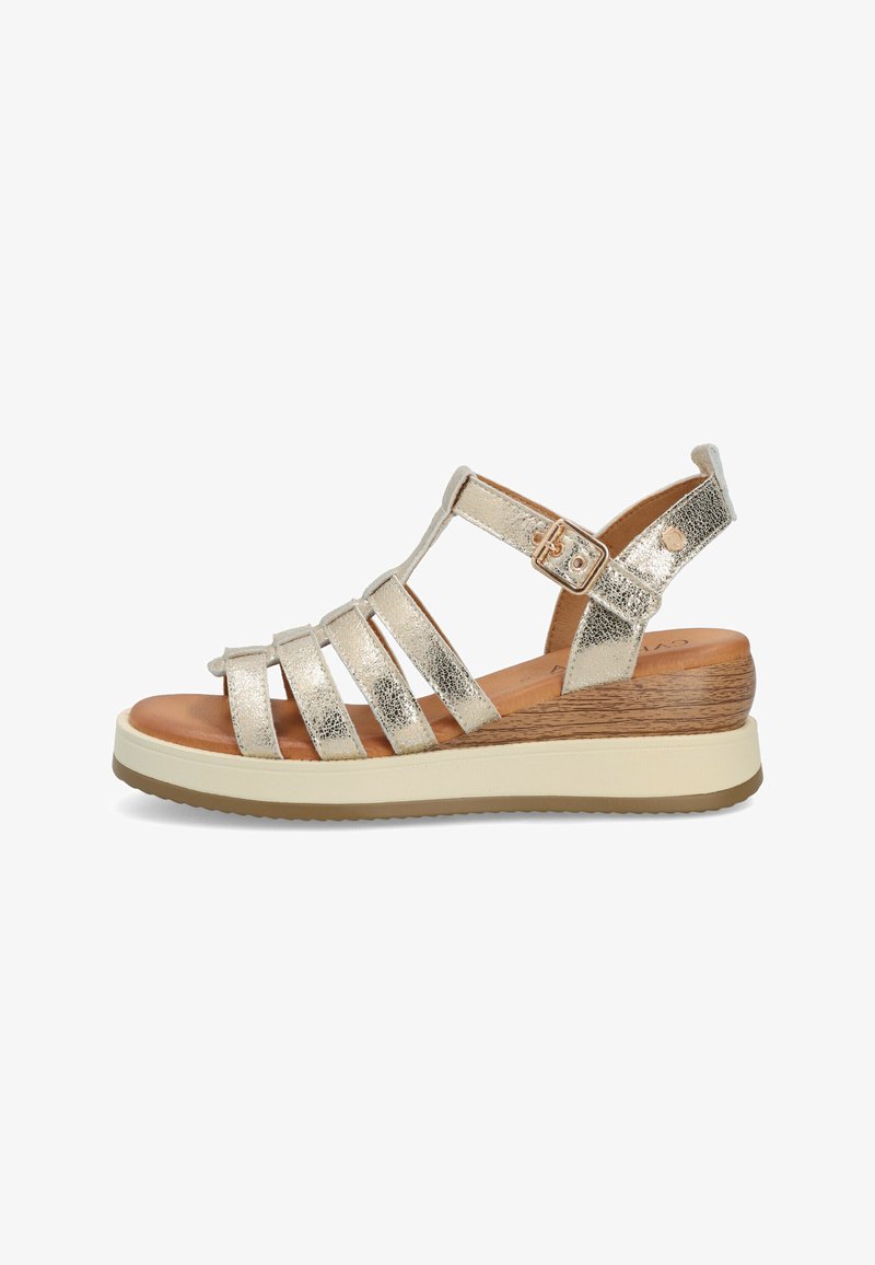 Sandalo strappato in oro metallizzato con una suola dal texture legno, una soletta imbottita e una cinghia alla caviglia regolabile; design leggero.
