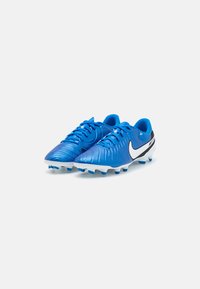 Botas de fútbol azules con un upper texturizado, logotipo de swoosh blanco y acentos negros. Diseñadas para ofrecer tracción con tacos moldeados en una suela blanca.