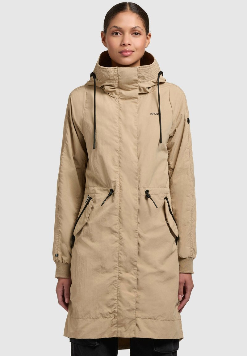 Bežna kapuca parka jakna iz lahkega materiala, ki ima sprednji zadrgo, dve stranski žepi in nastavljive vrvice na kapuci.
