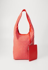 Rød vevd tote bag med et rutete mønster, med en avrundet håndtak og en matchende avtakbar rød pung. Glatt tekstur, mykt materiale.