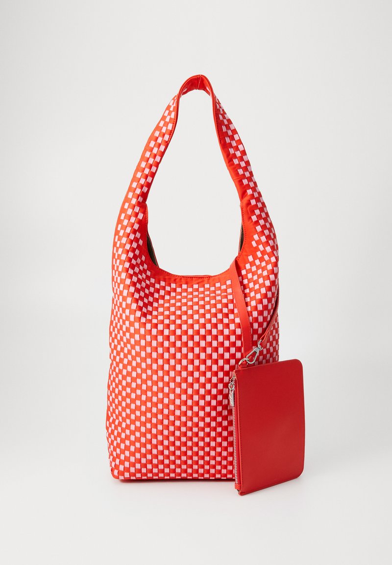 Rød vevd tote bag med et rutete mønster, med en avrundet håndtak og en matchende avtakbar rød pung. Glatt tekstur, mykt materiale.