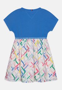 Niebieska bawełniana bluzka z krótkim rękawem, z wzorzystą spódnicą w pastelowych kolorach z ukośnymi liniami i markowym pasem.