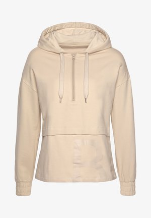 Beige hoodie met een halve ritssluiting aan de voorkant, elastische manchetten en een groot, semi-transparant "B" accent op de onderste voorkant. Zachte stoftextuur.