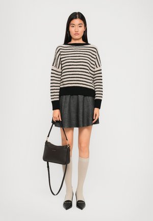 Striped knit sweater in cream and black, pleated gray skirt, knee-high beige socks, black handbag with gold hardware, pointed black flats.