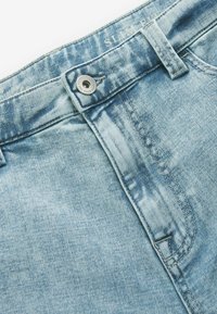 Jasnoniebieskie dżinsy o slim fit, z metalowym zapięciem, subtelnym wyblaknięciem i haftowanymi detalami na pasie.