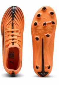 Oranje voetbalschoenen met een gestructureerde bovenkant, zwarte accenten, zes ronde noppen op de zool en een laag profiel voor wendbaarheid.