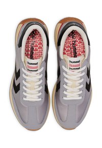 Hellgraue Turnschuhe mit schwarzen Akzenten, aus Netzmaterial, weißen Schnürsenkeln, Gummisohle und einer gemusterten roten Innensohle mit Markenlogo.