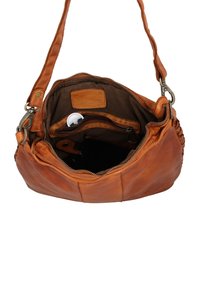 Brown leather shoulder bag with open zipper showing dark fabric interior and a white round tag attached inside pocket.