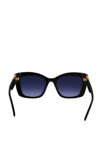 schildpadkleurige zonnebril met een cat-eye vorm. Donkere gradient lenzen. Gouden hardware accenten bij de scharnieren. Glad oppervlak.