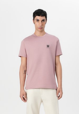 T-shirt en coton rose à manches courtes, avec un col rond et un petit logo noir sur la poitrine gauche. Texture lisse et coupe classique.
