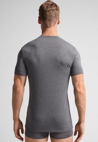 Szary bawełnowy t-shirt z krótkim rękawem i klasycznym okrągłym dekoltem, prezentowany z tyłu, charakteryzujący się gładką teksturą i dopasowanym krojem.