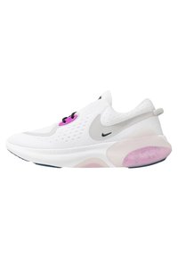 Chaussure de sport blanche avec une tige en maille respirante, des lacets noirs, des accents roses et une semelle amortissante avec une section translucide rose.