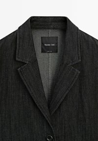 Veste en denim noir avec col cranté, fermeture à un bouton, et tissu texturé. Comprend une étiquette indiquant "Massimo Dutti" à l'intérieur.