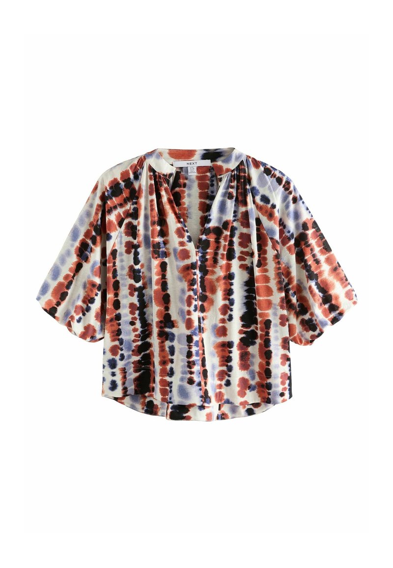 Blouse ample à manches courtes avec des rayures verticales tie-dye rouges, noires et bleues, et un col rond avec une petite fente sur le devant.