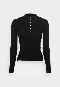 Haut noir à manches longues, en maille ajustée, avec un col montant et cinq boutons décoratifs blancs le long de la patte de boutonnage sur la poitrine.