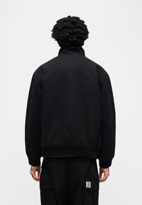 Μαύρο bomber μπουφάν με ψηλό γιακά, ριμπ μανσέτες και τελείωμα. Διαθέτει μινιμαλιστικό σχεδιασμό, κατασκευασμένο από απαλό ύφασμα με άνετη εφαρμογή.