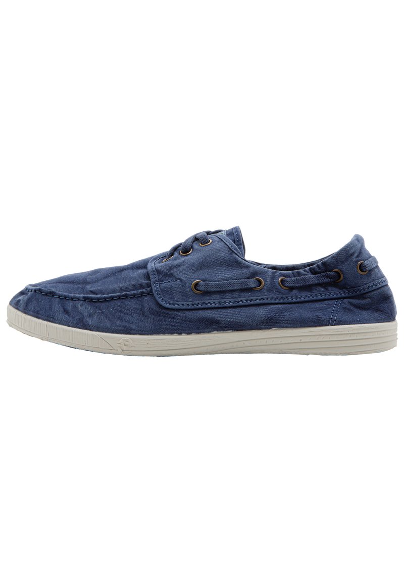 Kék vászon slip-on cipő kerek orral, puha szövettextúrával és bézs gumi talppal. Fém fűzőlyukakkal és varrási díszítésekkel rendelkezik.