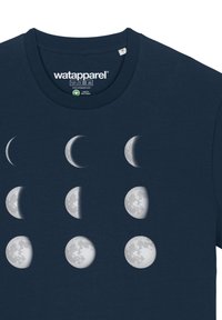T-shirt bleu marine avec un imprimé graphique des phases de la lune en blanc et gris. Présente un col rond et une texture en coton biologique douce.