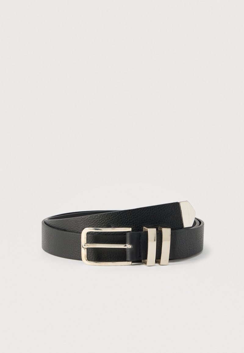 Μαύρη δερμάτινη ζώνη με υφή στην επιφάνεια, που διαθέτει ασημί αγκράφα διπλής δέσμης και μεταλλικές λεπτομέρειες, σχεδιασμένη σε κλασικό σχήμα.