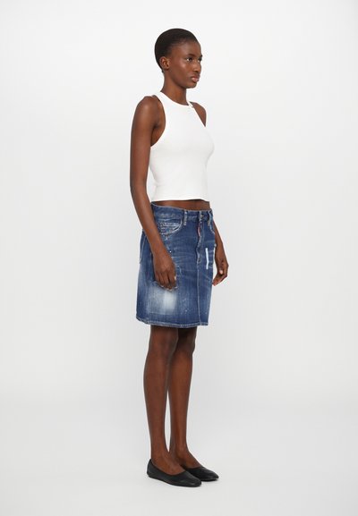 Jeansrock mit geradem Schnitt, hellblauem Farbton, Fronttaschen und leichter Verwaschung. Kombiniert mit einem weißen ärmellosen Oberteil und schwarzen Ballerinas.