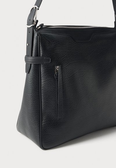 Sac à bandoulière noir en cuir grainé, avec fermeture éclair sur le dessus, bandoulière réglable, éléments métalliques argentés et poche avant zippée.