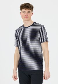 Námořnické a smetanové pruhované tričko s krátkým rukávem, kulatým výstřihem a volným střihem, vyrobené z měkké bavlněné tkaniny. Žádné viditelné vzory ani akcenty.