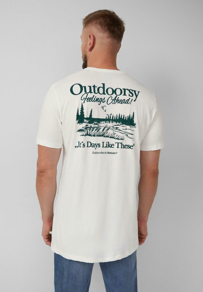 Witte katoenen t-shirt met een groene outdoor-thema grafiek op de achterkant, inclusief bomen en tekst. Korte mouwen en een relaxte pasvorm.