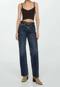 Top corto marrón, jeans de pierna recta de talle alto azul, cinturón marrón con hebilla, botines de tacón beige. Tela suave, textura de mezclilla.